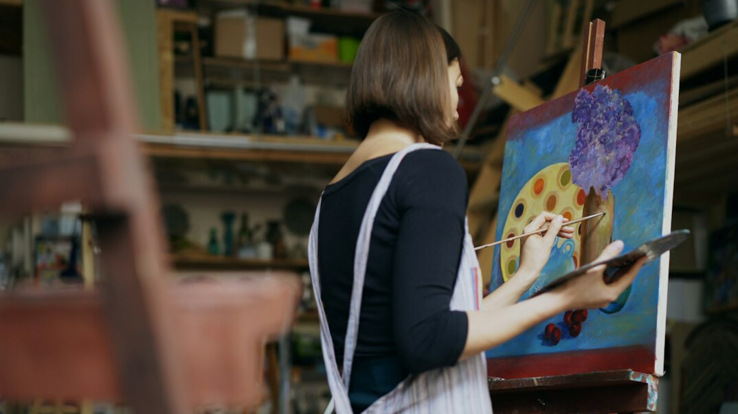 Senior European woman painting on canvas during an art workshop